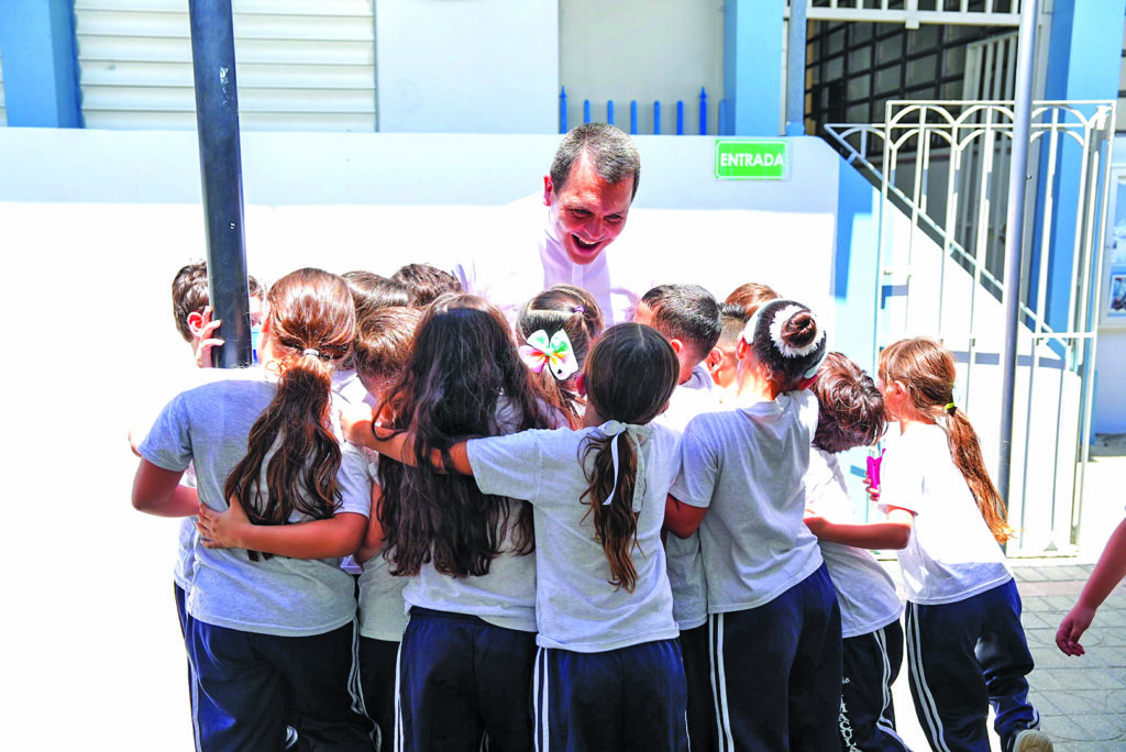 Padre Melvin Díaz Aponte, párroco de la Inmaculada Concepción rodeado de niños del Colegio parroquial